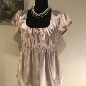 Cream colored beautiful satin top cinched at the waist, low cut neck line